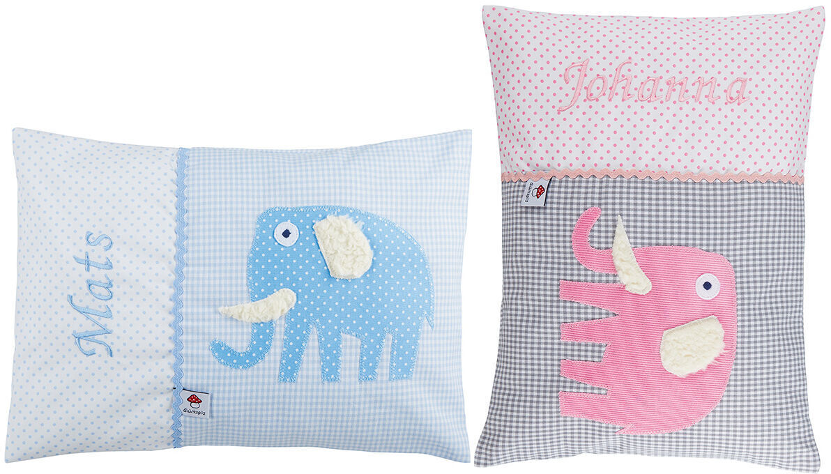 Zwei Namenskissen mit Elefantendesign. Das linke Kissen ist hellblau mit einem blauen Elefanten und dem Namen 'Mats'. Das rechte Kissen ist grau und pink mit einem pinken Elefanten und dem Namen 'Johanna'.