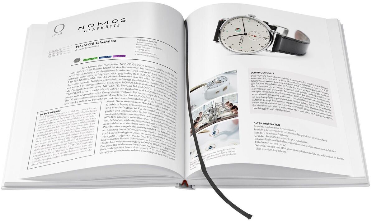 Offenes Buch mit dem Titel 'Deutscher Manufakturenführer', Aufschlag zeigt eine Seite über die Uhrenmarke NOMOS Glashütte mit Bildern und Text.