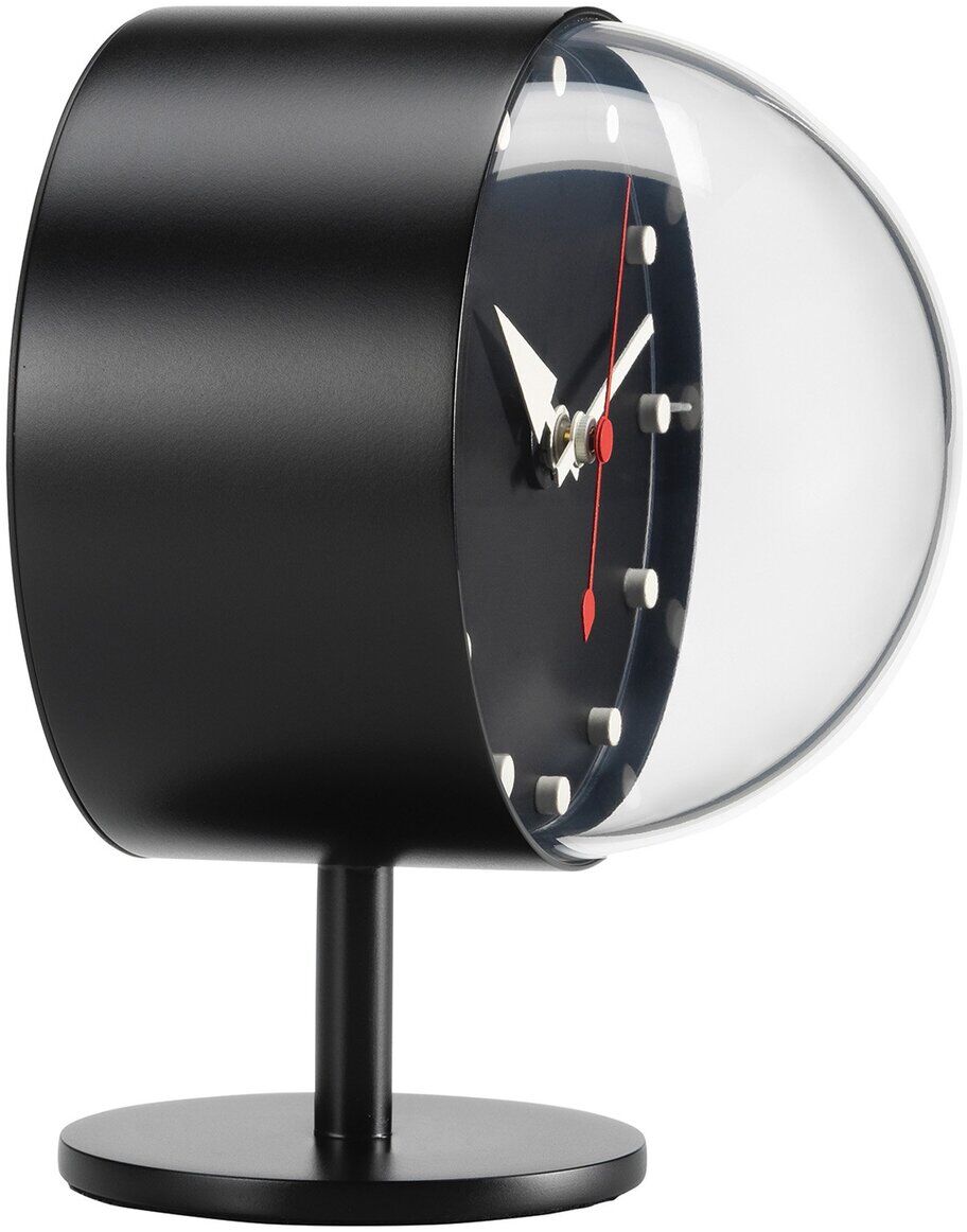 Die Tischuhr »Night Clock« von VITRA steht als Designerstück auf einem runden Standfuß. Das Gehäuse ist zylindrisch und schwarz mit einer gewölbten, transparenten Front. Das Zifferblatt ist dunkel, mit weißen Punkten, weißen Zeigern und einem roten Sekundenzeiger.