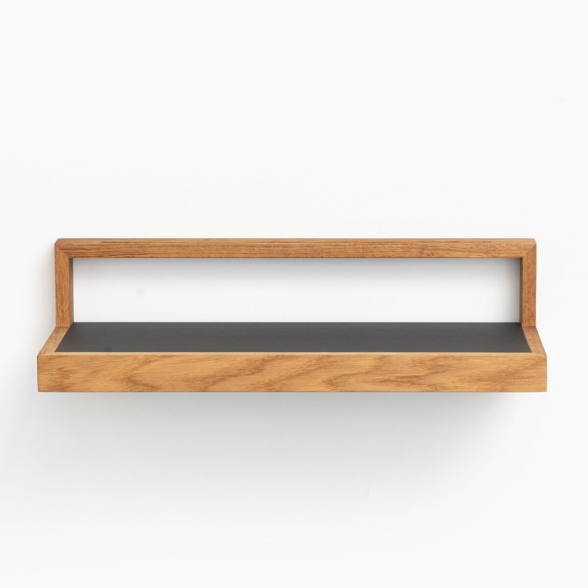 Ein schwebendes Ablagebord in anthrazit und Holzoptik vor einer weißen Wand. Das minimalistische Design eignet sich ideal zur Aufbewahrung und Dekoration in verschiedenen Räumen wie Wohnzimmer, Büro oder Flur.