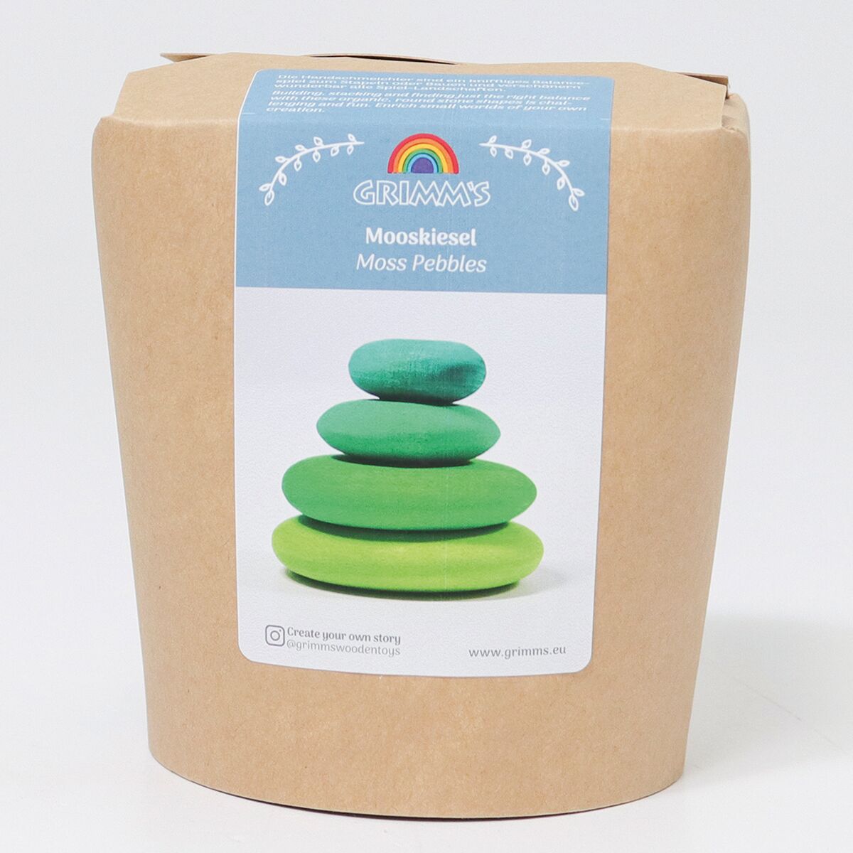 Abgebildet ist eine naturbraune Kartonverpackung mit blauem Etikett von GRIMM’S. Auf dem Etikett ist ein Foto von vier übereinandergestapelten, unterschiedlich grünen Holzsteinen in Kieselsteinform zu sehen. Oberhalb steht der Name 'Mooskiesel', darunter die englische Übersetzung.