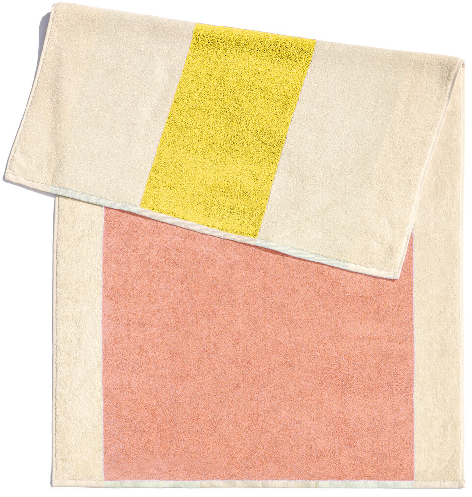 Badematte, 50 x 80 cm, mit einem modernen Design. Die Matte ist beige mit einem gelben Streifen und einem lachsrosa Bereich.