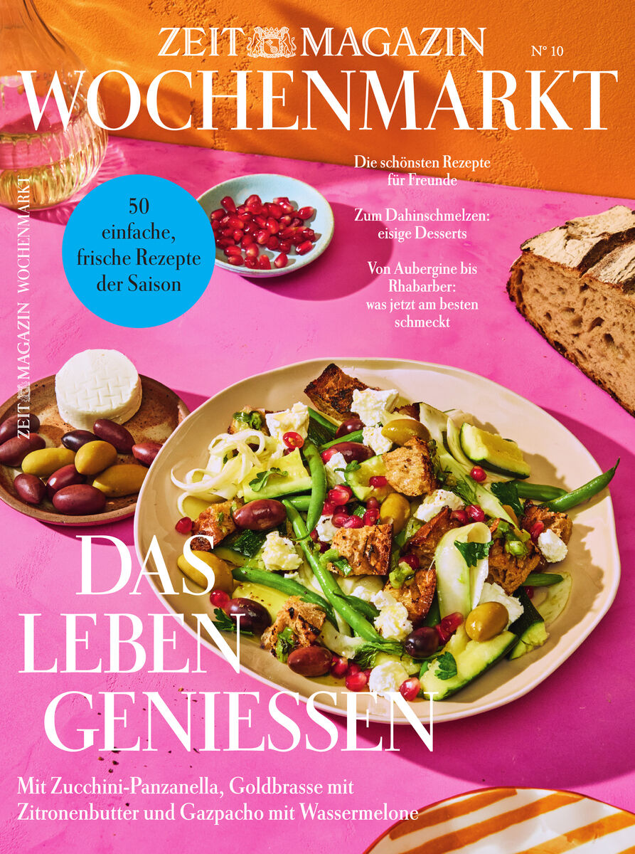Das Cover des ZEITmagazin WOCHENMARKT 10/26 zeigt einen hellen Tisch mit farbenfrohen Speisen: Ein großer Teller mit frischem Salat, Brotwürfeln, grünen Bohnen, Tomaten und Oliven, daneben ein Brett mit Oliven, ein Schälchen Granatapfelkerne und rustikales Brot. Text hebt Saisonrezepte hervor.