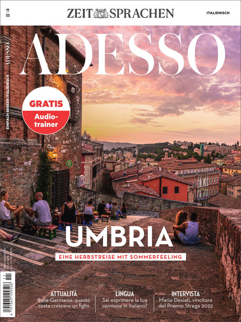 Cover der Zeitschrift Adesso Heft 11/2022 mit dem Titel 'Umbria - Eine Herbstreise mit Sommerfeeling'. Das Bild zeigt eine mediterrane Stadtlandschaft in Umbrien bei Sonnenuntergang. Oben links steht 'Gratis Audio-Trainer'.