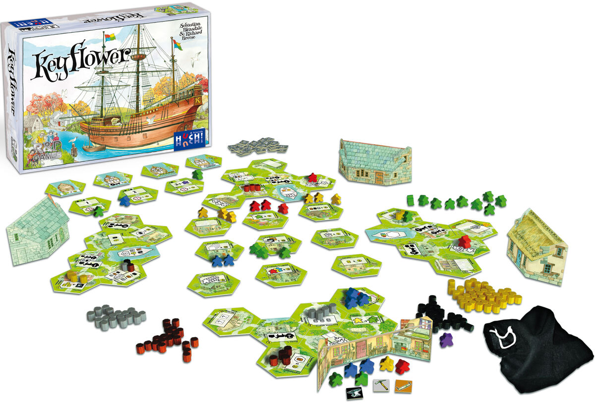 Auf dem Bild ist das Brettspiel Keyflower zu sehen. Das Spiel besteht aus einer Schachtel, mehreren sechseckigen Spielplanteilen, kleinen bunten Holzfiguren, Häusern und anderem Spielmaterial, das auf einem weißen Hintergrund verteilt ist. Die Szene vermittelt einen Eindruck von strategischem Brettspielspaß für Familien und Gruppen.