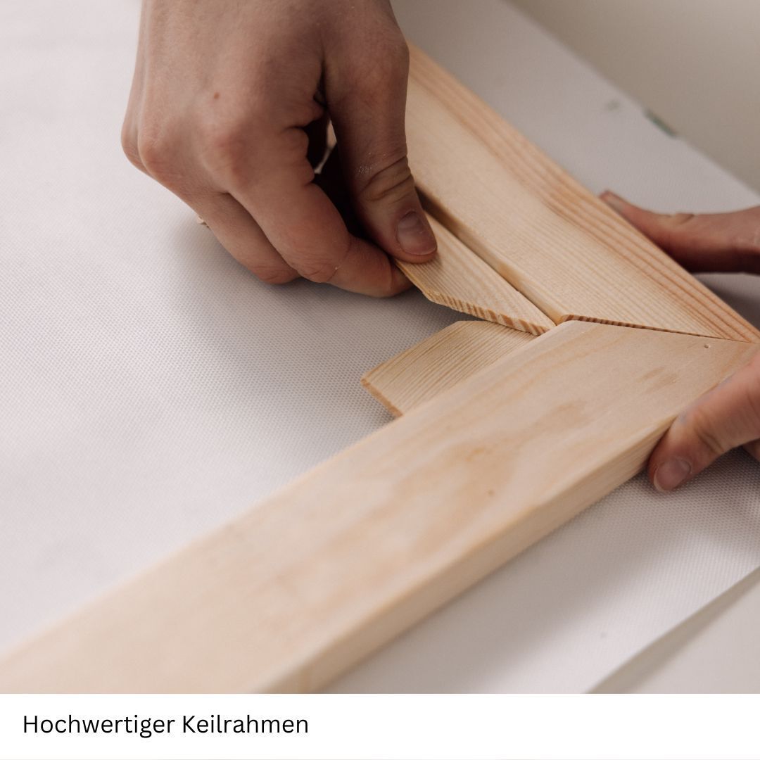 Hände, die einen hochwertigen Keilrahmen zusammenbauen. Verschiedene Holzstücke werden in einem Winkel aneinander gefügt.