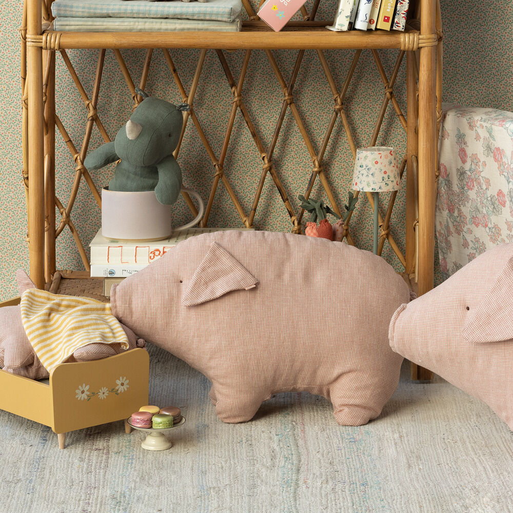 Großes Kuscheltier Schwein »Polly« (50 cm) aus rosa Stoff mit karierter Textur, umgeben von anderen farbenfrohen Spielsachen, platziert auf einem Kinderzimmerregal.