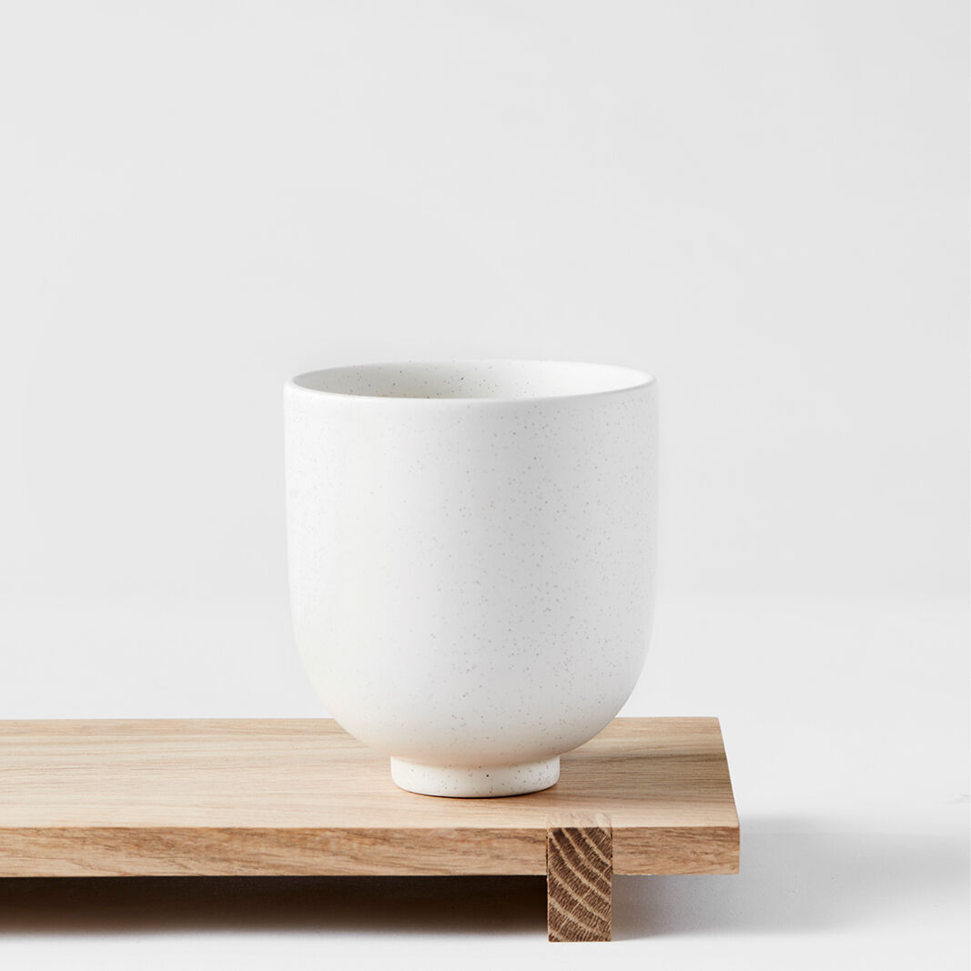 Ein minimalistisches japanisches Holzbrett mit einer weißen Teetasse darauf. Das Design ist schlicht und elegant, ideal für traditionelle Teezeremonien oder als dekoratives Küchenelement.
