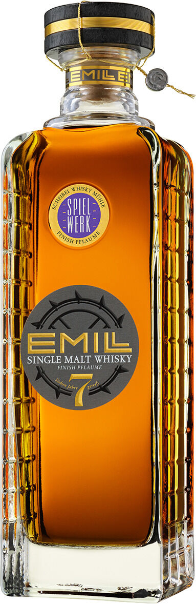 Freigestellte, hohe Flasche des Single Malt Whisky „EMILL Spielwerk“ 7 Jahre von Scheibel Brennerei. Der bernsteinfarbene Whisky steht in einer kantigen, klaren Glasflasche mit gerippten Seiten. Schwarzer, goldgeränderter Verschluss mit Siegelanhänger; graues Rundetikett und blau-goldenes Spielwerk-Siegel vorn.
