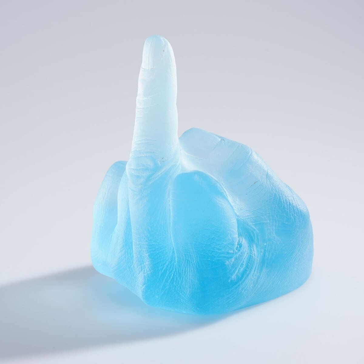 Eine Skulptur von Ai Weiwei mit dem Titel »Study of Perspective in Glass«, bestehend aus einer blau getönten Glasnachbildung einer Hand, die den mittleren Finger zeigt. Die Plastizität der Hand und die differenzierten durchsichtigen Bereiche vermitteln einen modernen und provokanten Eindruck.