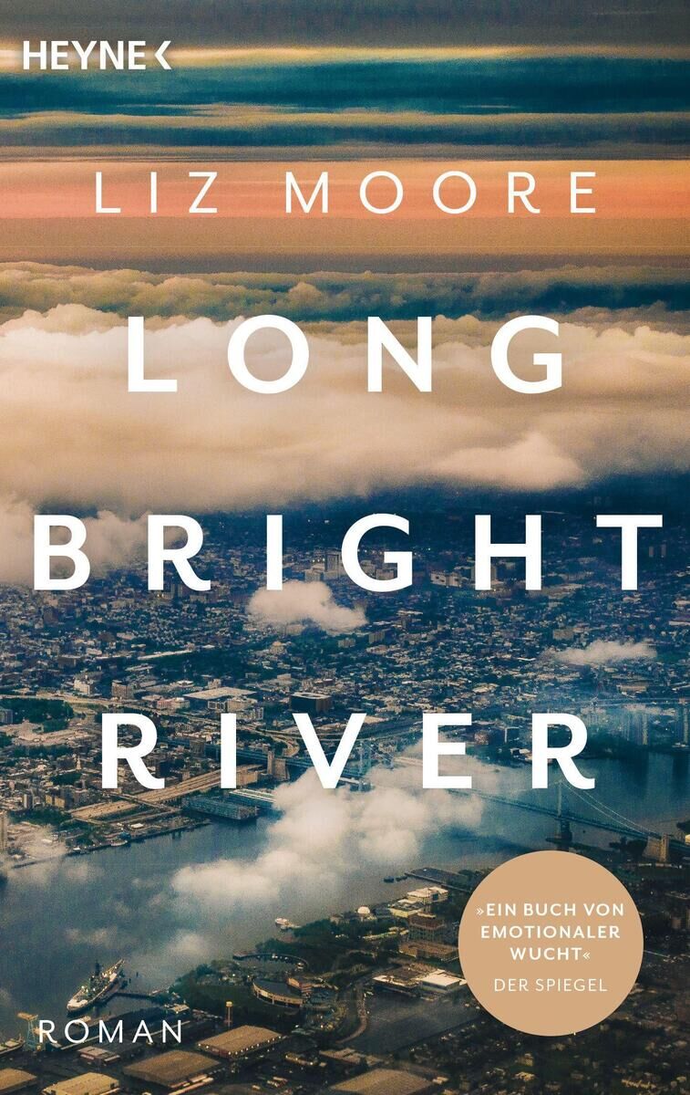 Das Cover des Buches 'LONG BRIGHT RIVER' von Liz Moore zeigt eine Luftansicht einer Stadt mit Wolken und einem Wasserlauf im Vordergrund. Oben steht 'HEYNE' und dann 'Liz Moore'. Unten links steht 'Roman'.