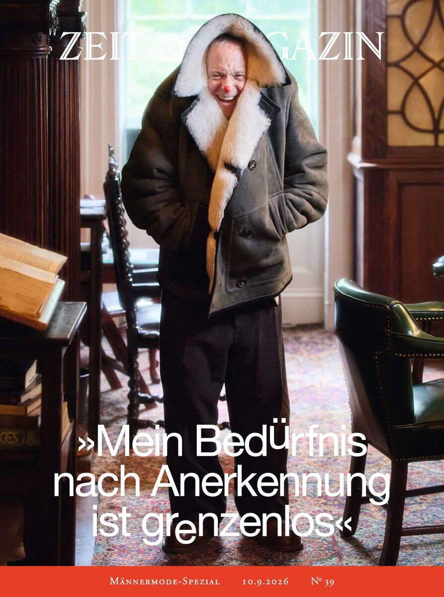 Cover des ZEIT Magazins 39/2026 mit einem Mann im warmen Parka mit Fellkragen, stehend in stilvollem, holzvertäfeltem Raum, Bücher im Hintergrund, Zitat: „Mein Bedürfnis nach Anerkennung ist grenzenlos.“ Männermode-Spezial, 10.9.2026.