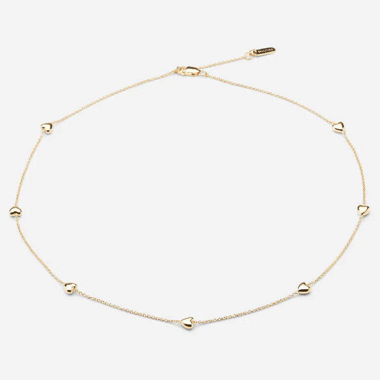 Filigranes Collier aus vergoldetem 925er Sterlingsilber mit sieben kleinen, einzeln platzierten Herzanhängern entlang einer feinen, goldfarbenen Kette. Die Kette besitzt einen dezenten Glanz und einen verstellbaren Verschluss. Das Design wirkt zart, hochwertig und elegant.