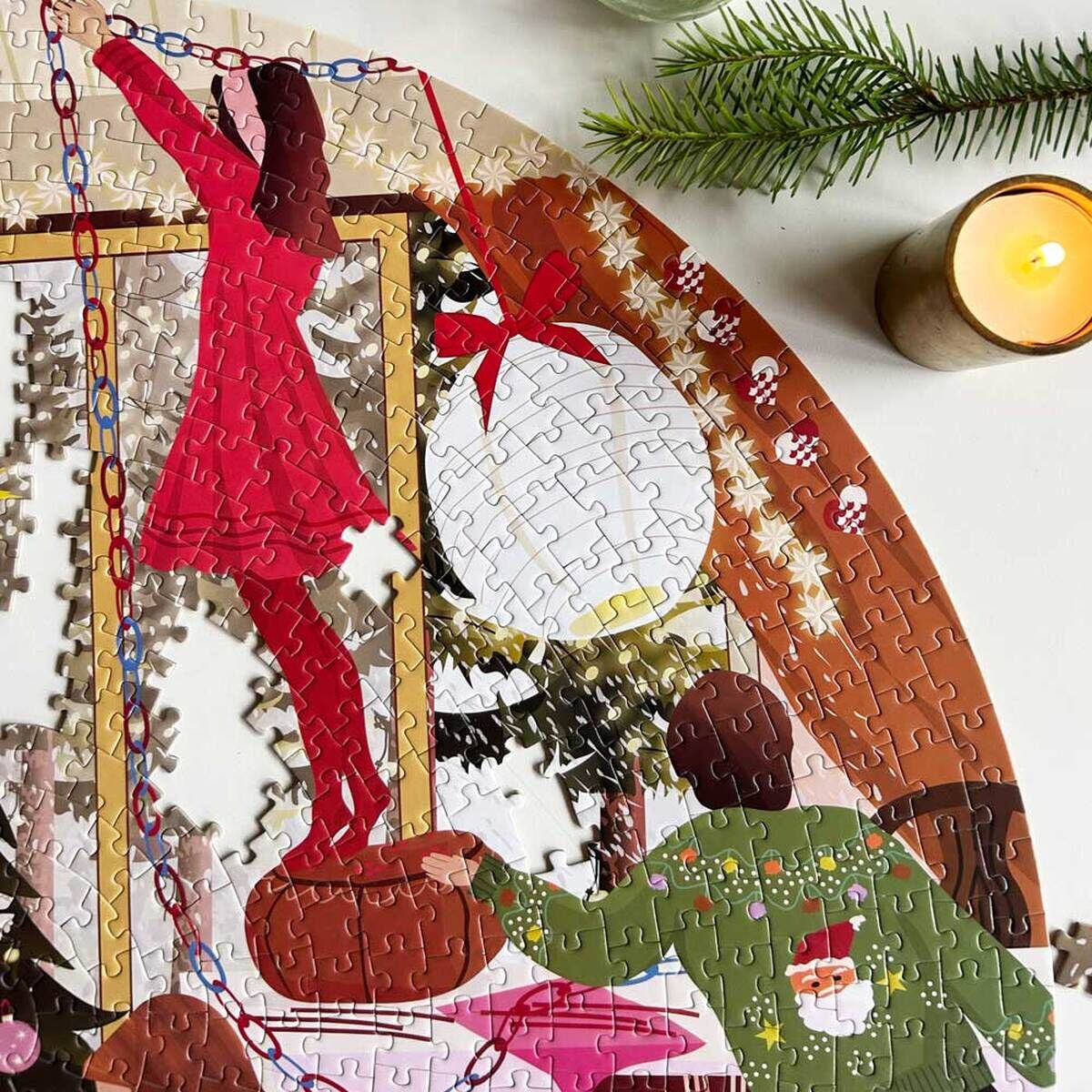 1000-Teile Puzzle mit weihnachtlicher Szene, das eine Frau im roten Kleid und Stiefeln zeigt, die auf einem Hocker steht und einen Weihnachtsbaum mit festlicher Dekoration schmückt. Daneben steht eine weitere Person, umgeben von Weihnachtsbaumschmuck, Kerzen und Tannenzweigen. Das Puzzle liegt teilweise fertig auf einem Tisch mit weiteren festlichen Accessoires.