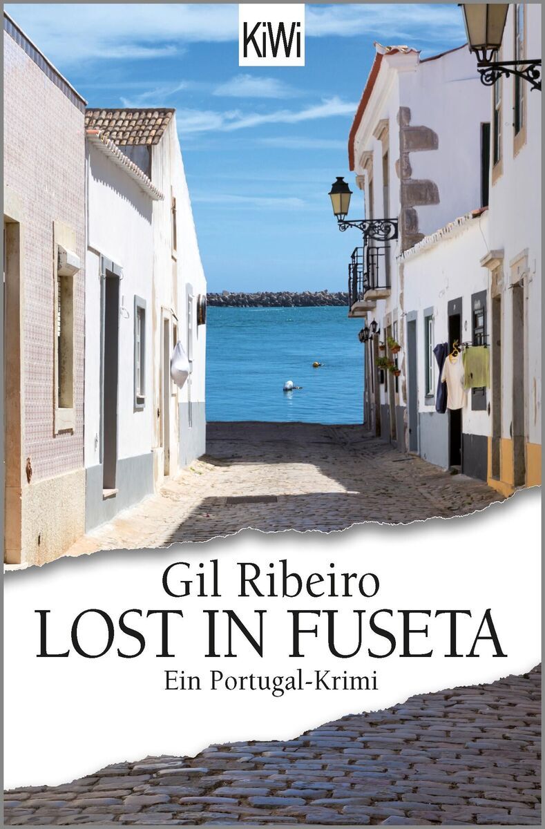 Das Cover des Buches 'Lost in Fuseta' von Gil Ribeiro zeigt eine enge, gepflasterte Gasse in einer Küstenstadt mit weißen Häusern, die zum Meer führt. Das Meer ist in Blau zu sehen, und im Vordergrund befindet sich der Titel des Buches.