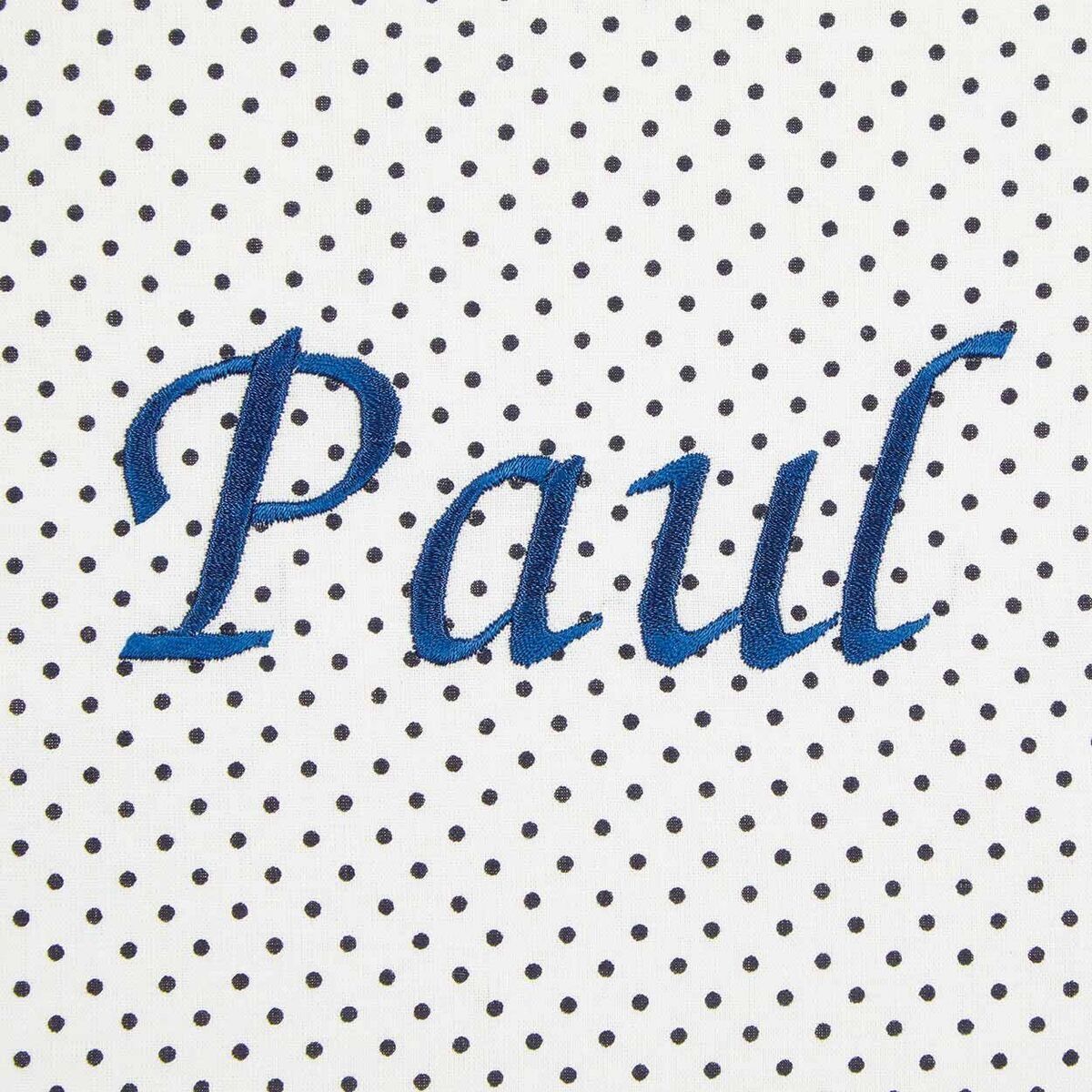 Eine weiße Baby-Kuscheldecke mit blauen Punkten und dem Namen 'Paul' in blauer Schrift in der Mitte.