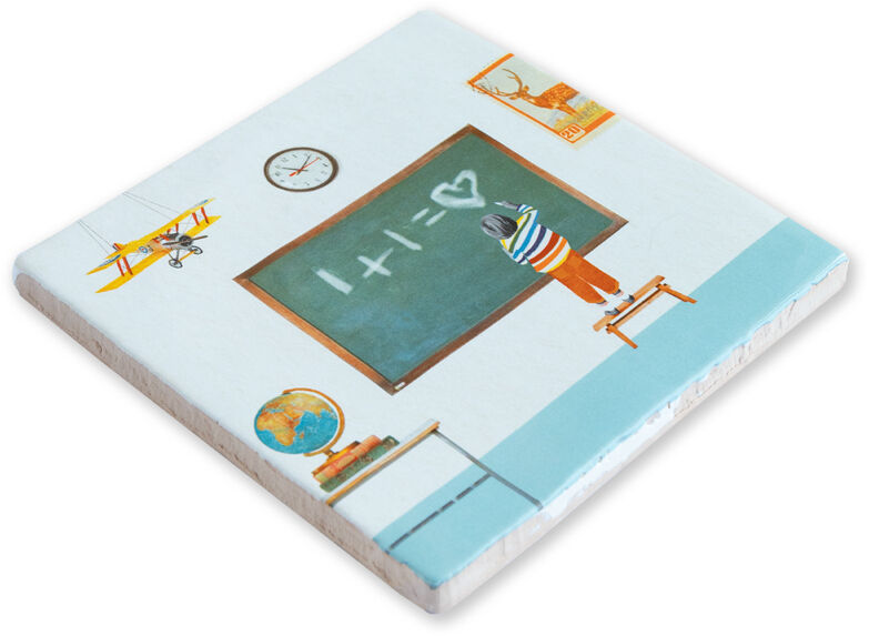 Bild einer quadratischen Keramikfliese mit einer Illustration eines Klassenzimmers. Auf der Tafel steht 1+1=♡. Ein Kind steht vor der Tafel. Weitere Elemente sind ein Globus, eine Uhr und ein Poster an der Wand, sowie ein Modellflugzeug an der Decke.
