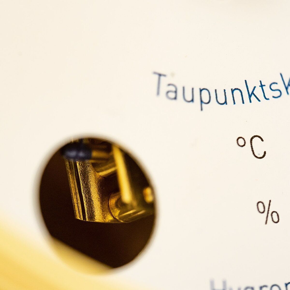 ZEIT-Sonderedition »POLAR Haar-Hygrometer« zeigt Taupunktskala mit Temperatur- und Feuchtigkeitsanzeige auf weißem Hintergrund. Ein kleiner goldener Ausschnitt des Geräts ist sichtbar.