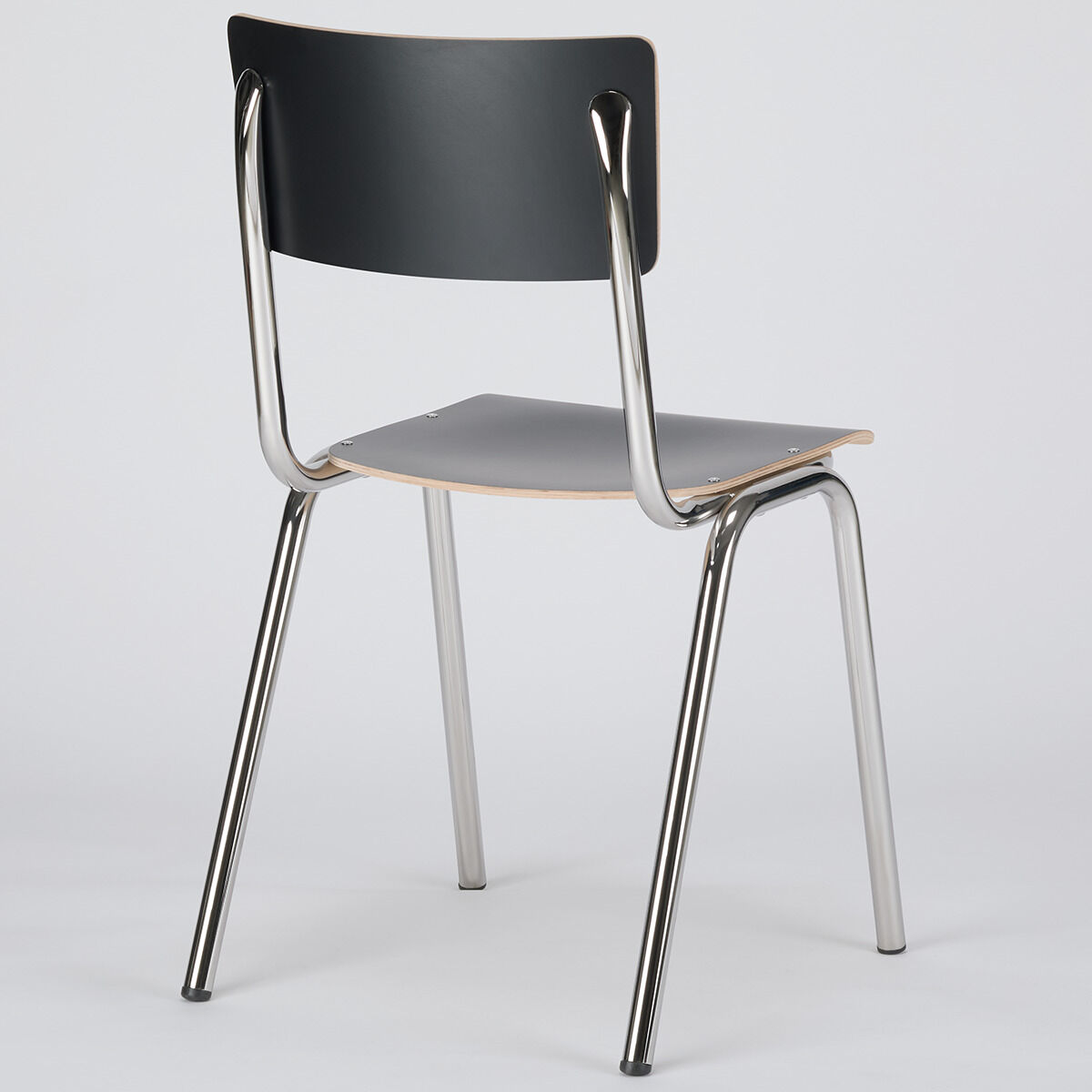 Ein moderner Stuhl namens ZEIT-Sonderedition Stuhl »ZERO« mit einem schwarzen Sitz und Rückenlehne aus Holz sowie silbernen Metallbeinen vor einem neutralen Hintergrund.