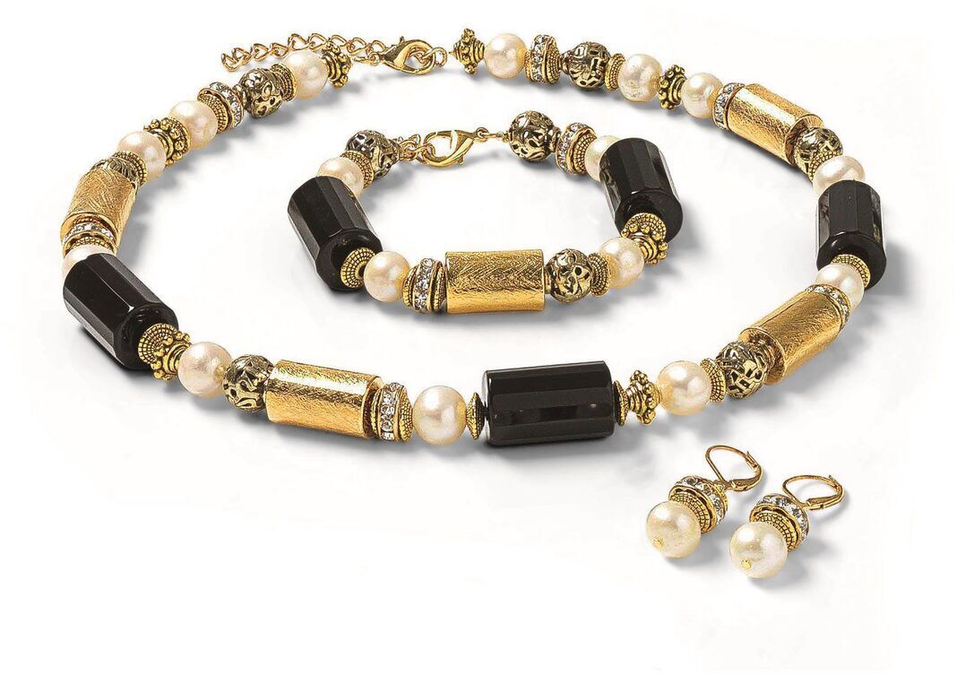 Schmuckset 'Opulent' von Waszak, Petra, bestehend aus einer Halskette, einem Armband und Ohrringen mit schwarzen, goldenen und weißen Perlen, präsentiert auf weißem Hintergrund.