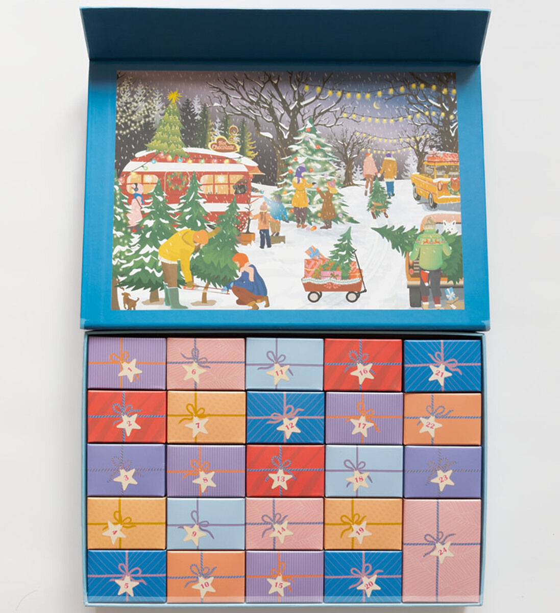 Ein geöffneter Puzzle-Adventskalender mit einzeln gestalteten, bunten Schachteln in einem rasterförmigen Muster. Im Deckel befindet sich eine winterliche Illustration von Menschen, die Weihnachtsbäume auf einem verschneiten Marktplatz kaufen, umgeben von Tannenbäumen, Lichterketten und Verkaufsständen.