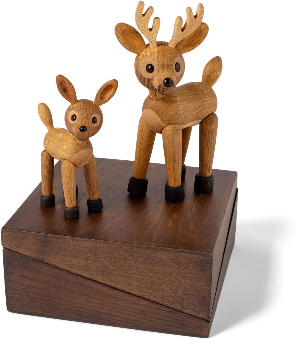 Zwei aus Holz gefertigte Tierfiguren, ein größeres und ein kleineres Reh, stehen gemeinsam auf einer dunkelbraunen, würfelförmigen Holzplattform. Die Figuren haben schwarze Hufe und betonte schwarze Augen. Das Ensemble eignet sich als dekoratives Wohnaccessoire für verschiedene Anlässe, insbesondere zur Weihnachtszeit.