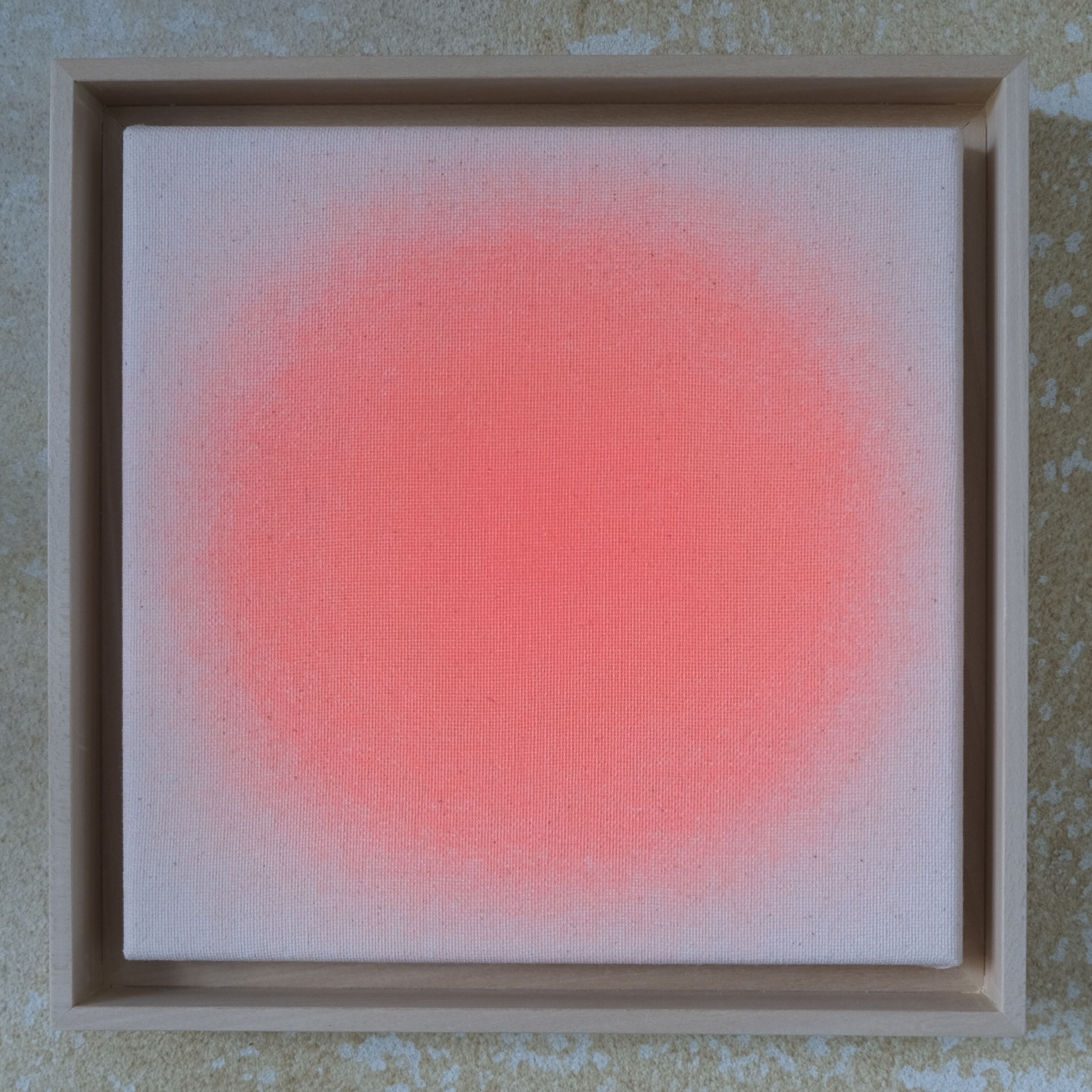 Quadratisches Kunstwerk in hellem Lindenholzrahmen, mittig ein zarter Kreis in Apricot-Orange auf naturfarbener, unbehandelter Leinwand. Der apricotfarbene Farbverlauf wirkt wie ein sanfter, transparenter Nebel und hebt sich weich vom beigen Hintergrund ab. Das Bild strahlt Leichtigkeit und Ruhe aus.