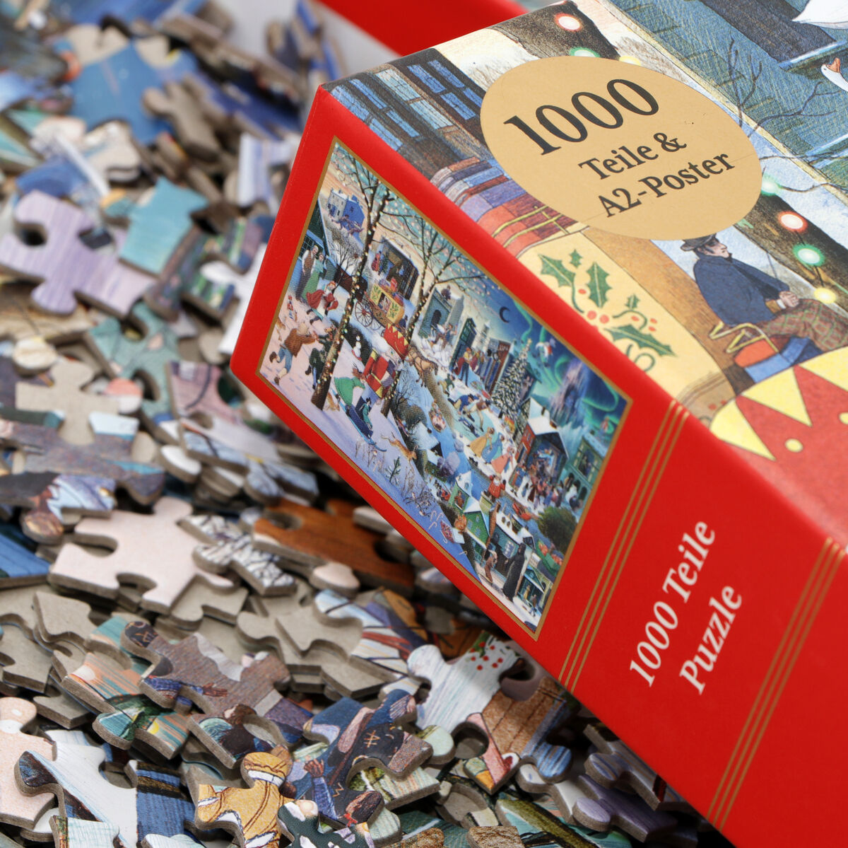 Ein Puzzle mit dem Titel »Literarisches Weihnachten«, bestehend aus 1000 Teilen und einem A2-Poster, in einer roten Verpackung. Das Bild zeigt verstreute Puzzleteile und das vollständige weihnachtliche Motiv auf der Schachtel.