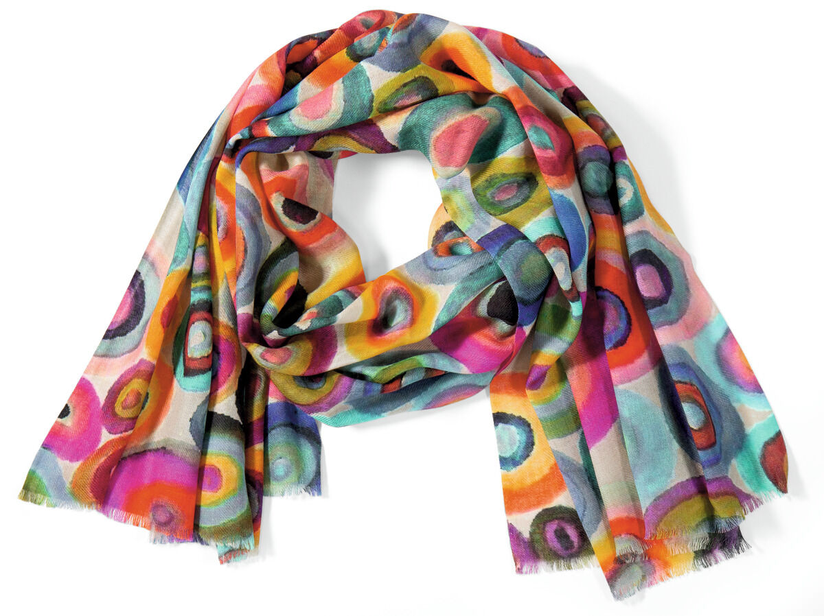 Der Schal „Colorful Moments“ liegt locker drapiert auf einer hellen Fläche. Er zeigt einen fließenden Farbverlauf aus Pink, Orange, Gelb, Blau, Violett und Grün mit weichen Übergängen. Das Material wirkt leicht und transparent mit zartem Glanz. Feine Webstruktur und sanft schimmernde Farben verleihen dem Schal ein lebendiges, edles Aussehen.