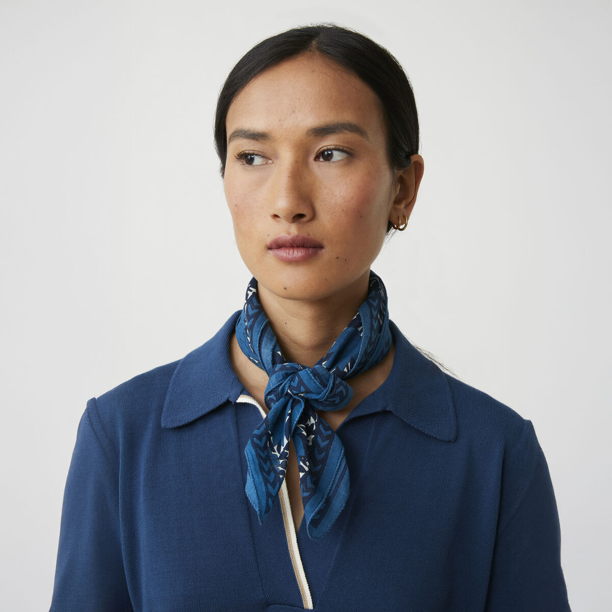 Quadratisches Baumwolltuch »No. 791« von MOISMONT in Indigo, 67 x 67 cm, mit zweifarbigem, detailliertem floralen Blockdruck in verschiedenen Blautönen. Chevron-Bordüre rahmt das Muster, dezenter MOISMONT-Schriftzug in einer Ecke. Textile, weiche Struktur sichtbar.