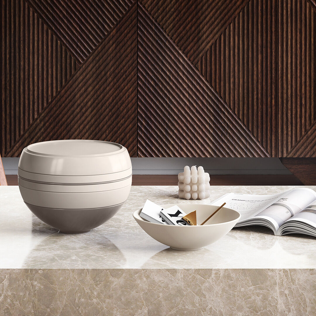 Geschirr-Set 'La Boule' in modernem, minimalistischem Design auf einem Marmor-tisch. Das Set besteht aus einem keramischen Kugelbehälter und Schüssel vor einer dekorativen Holzwand.