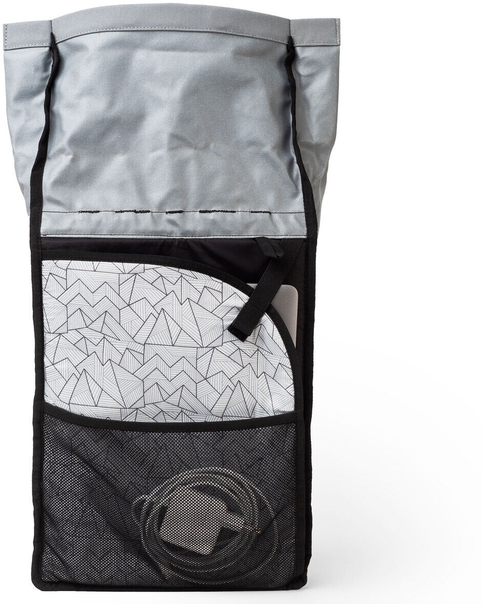 Ein grauer Rucksack mit schwarz abgesetzten Nähten, der vorne ein Netzelement zeigt. Der Rucksack hat ein schlichtes Design und zeigt ein Muster im oberen Bereich.