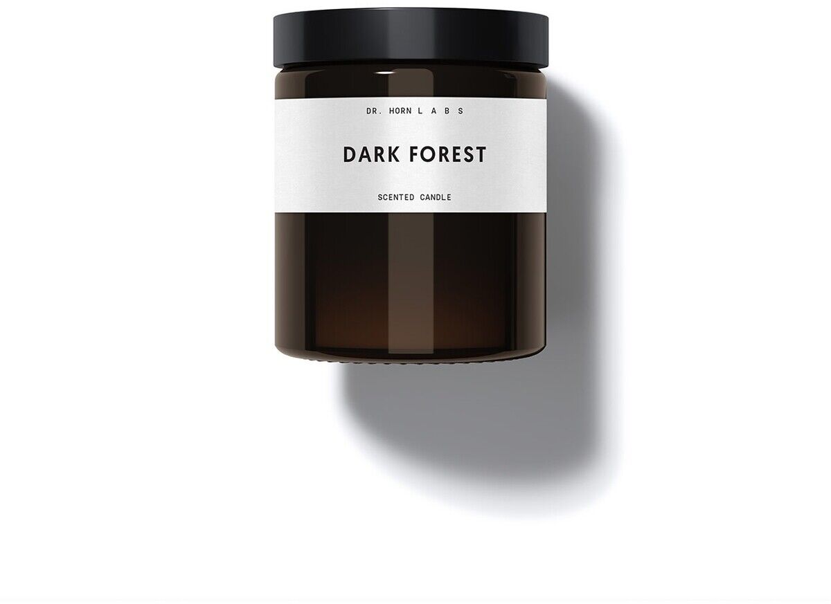 Duftkerze aus Sojawachs in einem dunklen Glasbehälter mit weißem Etikett und schwarzem Deckel, beschriftet mit 'Dark Forest'.