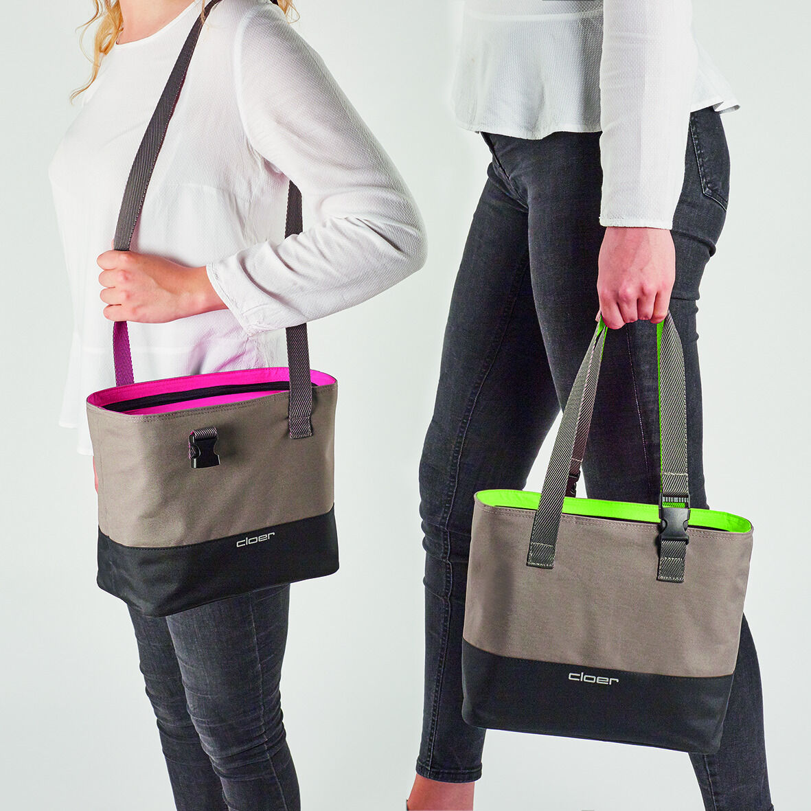Zwei Personen tragen Lunch-Taschen, eine mit grauem und pinkem Design und eine mit grauem und grünem Design. Beide Taschen sind aus Stoff und haben Tragegriffe.