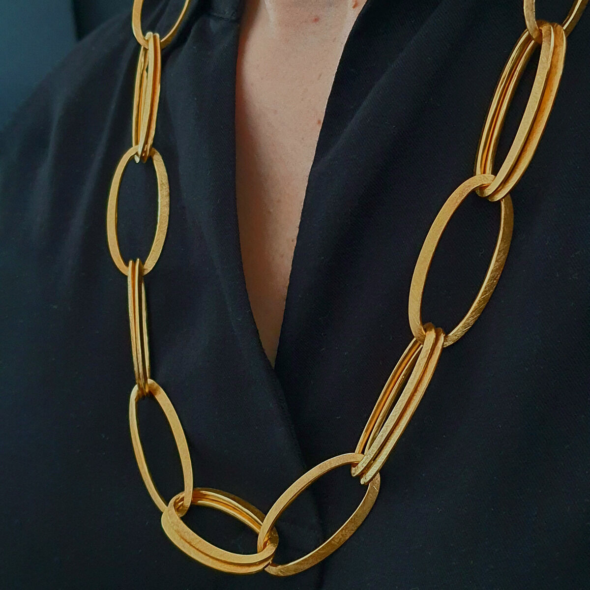Nahaufnahme des feingoldplattierten Colliers »GRACE« von HML Berlin aus großen, ellipsenförmigen Gliedern an einem Hals über einem schwarzen Oberteil. Das Schmuckstück wirkt modern, hochwertig und stilvoll, ideal für besondere Anlässe.