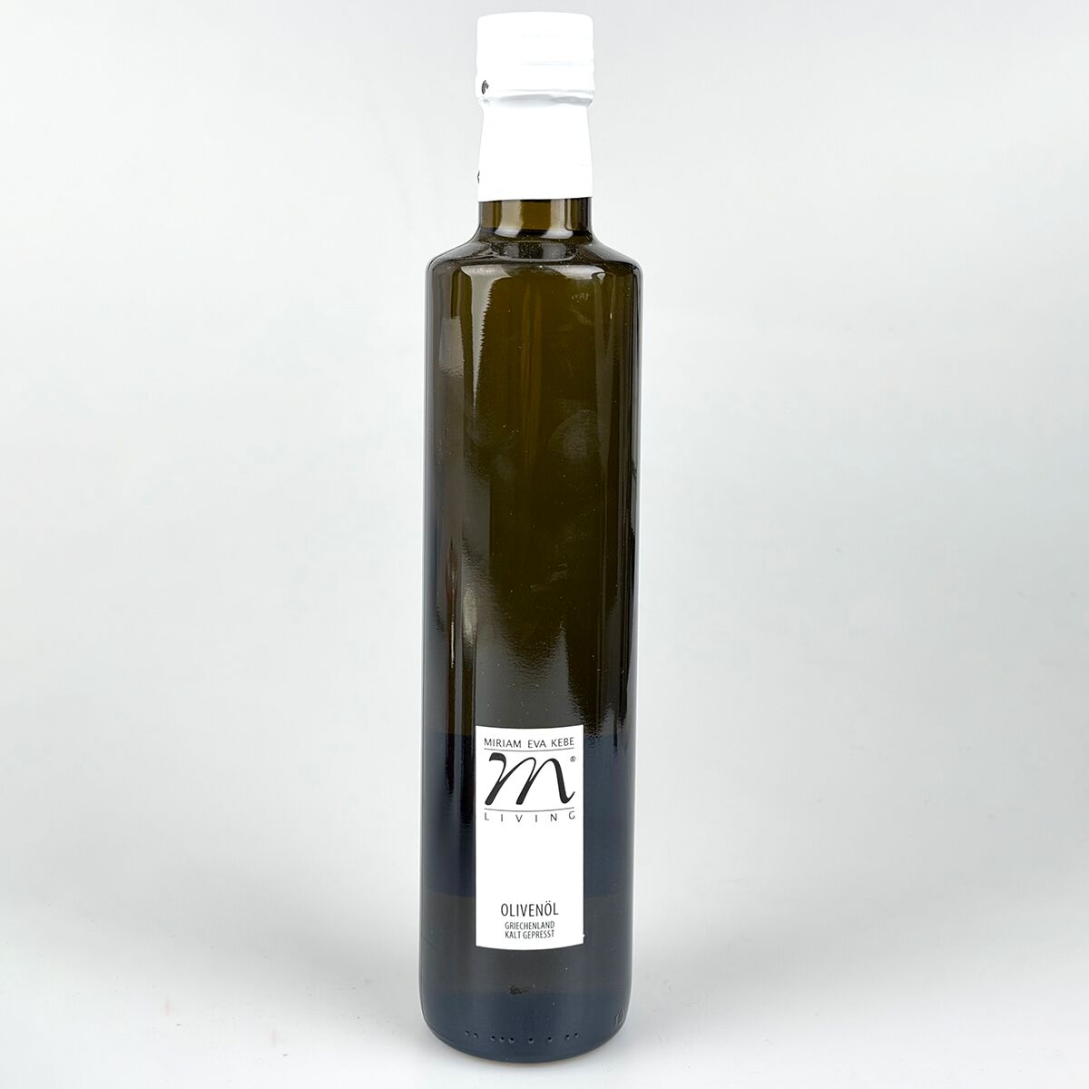 Eine dunkelgrüne Glasflasche mit weißem Verschluss, auf der ein minimalistisches Etikett mit der Aufschrift "Olivenöl" und einer stilisierten Marke in Schwarz und Weiß zu sehen ist. Die Flasche steht aufrecht vor neutral hellem Hintergrund.
