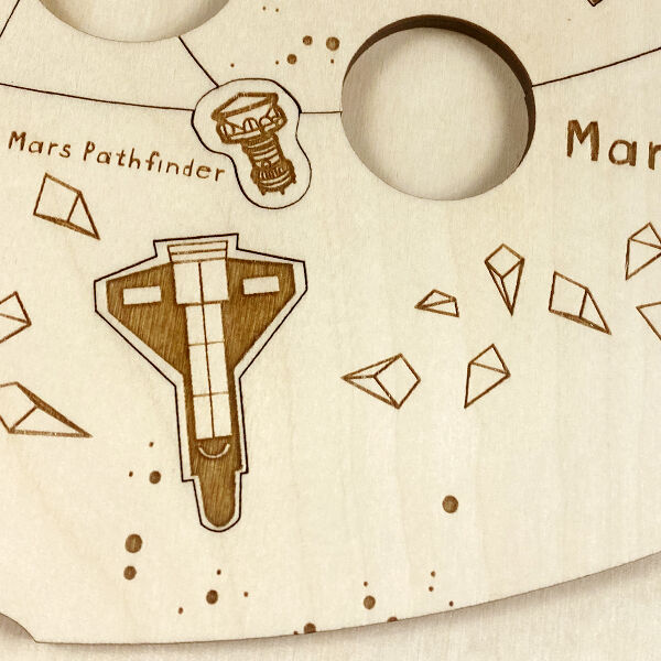 Holzpuzzle »Kosmos«, handgemachtes Puzzle aus hellem Holz, mit eingravierten Darstellungen von Planeten und Raumfahrzeugen wie dem Mars Pathfinder. Ideal für Kinder und Erwachsene, die an Astronomie und Wissenschaft interessiert sind.