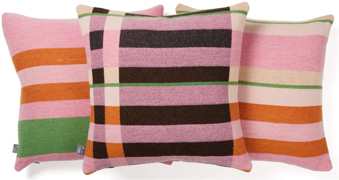 Drei Kissen im Bauhaus-Stil von Stölzl mit geometrischen Mustern und Streifen in Rosa, Orange, Grün, Schwarz und Cremefarben.