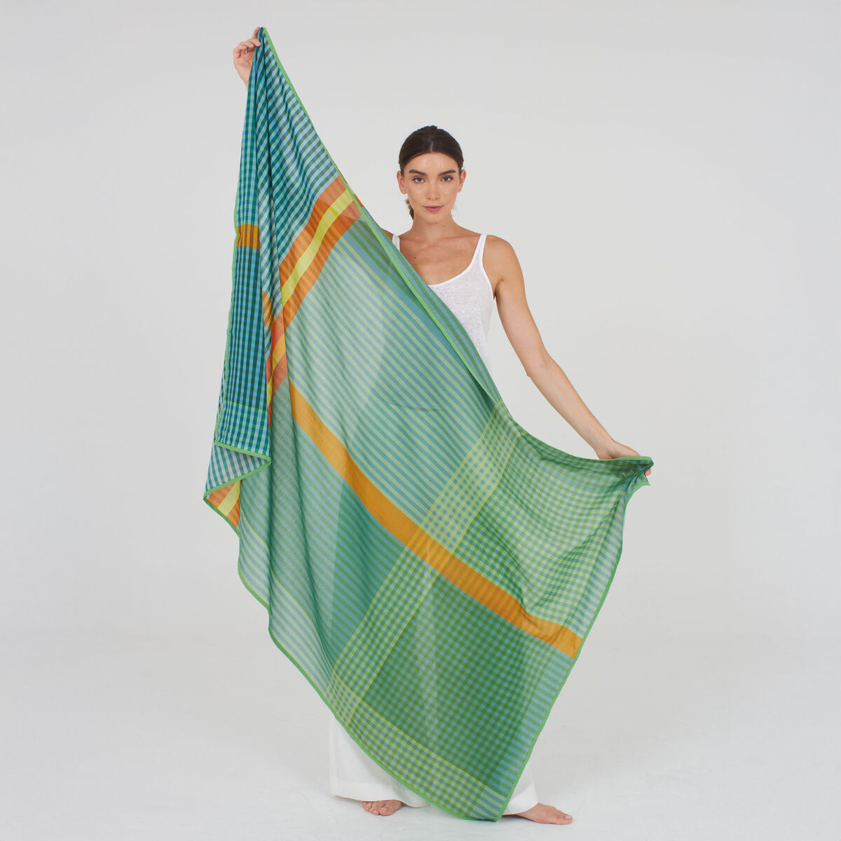 Auf dem Bild ist ein leichter, eleganter Baumwoll-Seidenschal »Willa« von Shalls Barcelona in sanften Grüntönen mit weißen Elementen zu sehen. Der Schal ist halbtransparent, großformatig (100x180 cm), weich fallend und fein gewebt. Das Material wirkt hochwertig und edel.