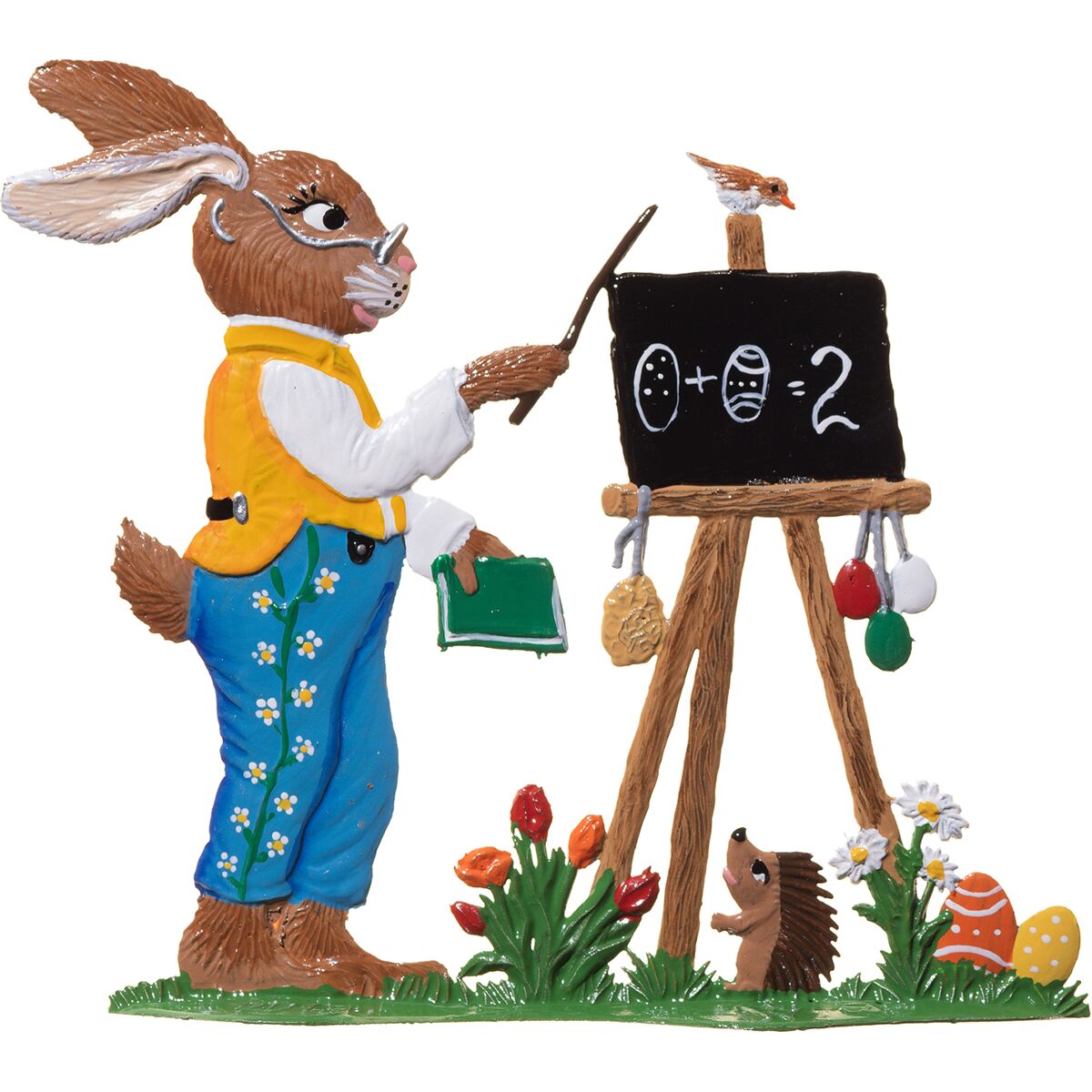 Detaillierte Zinnfigur eines Hasenlehrers von Wilhelm Schweizer Zinnmanufaktur: Ein Hase mit gelber Weste und blauer Hose steht vor einer Schultafel, zeigt mit einem Stock auf die Tafel, hält ein grünes Buch. Um ihn herum Blumen, Ostereier, ein Igel und ein Vogel auf der Tafel.