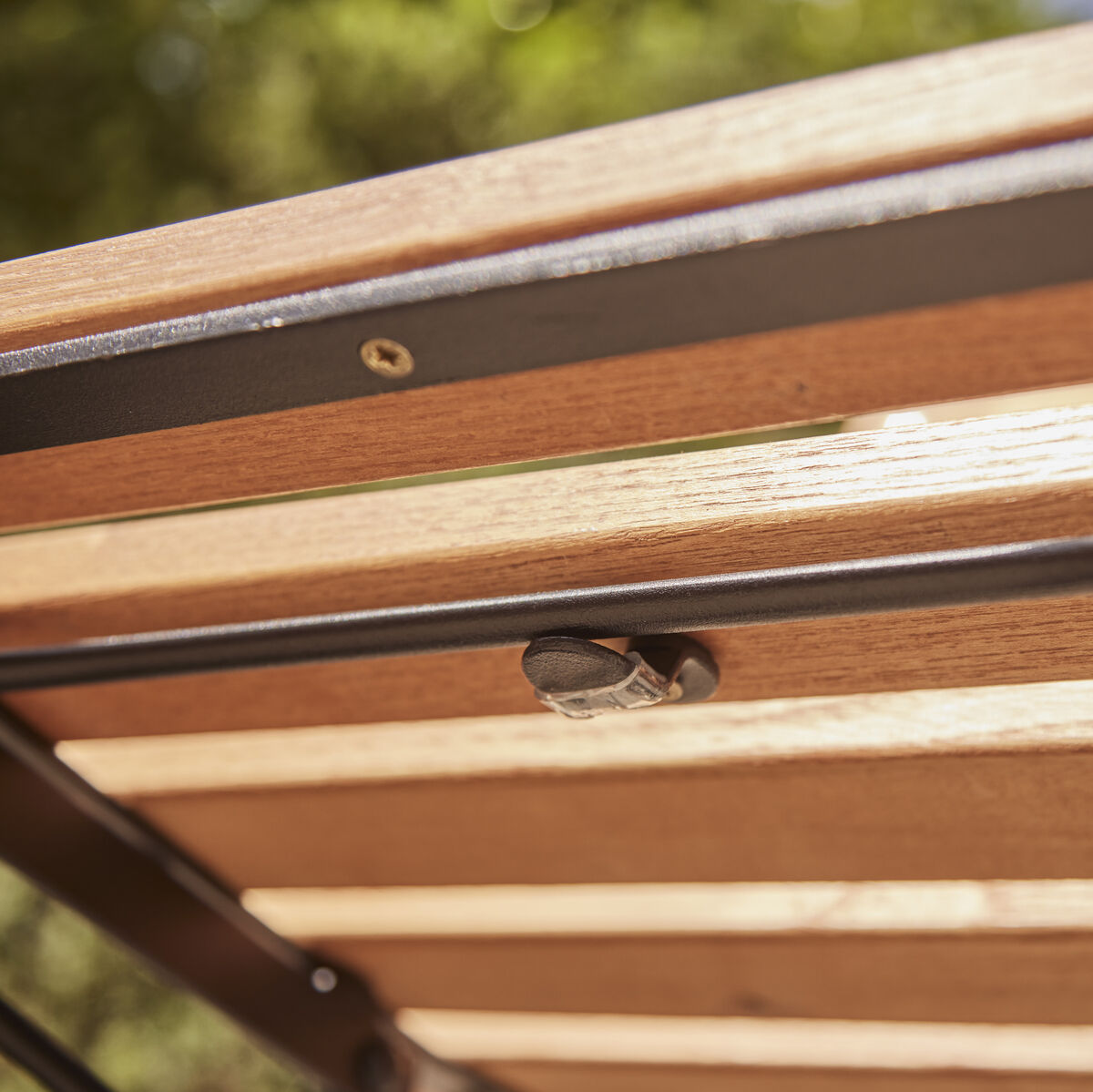 Nahaufnahme eines Klappsessels 'Peru' aus Holz und Metallrahmen, geeignet für den Außenbereich.