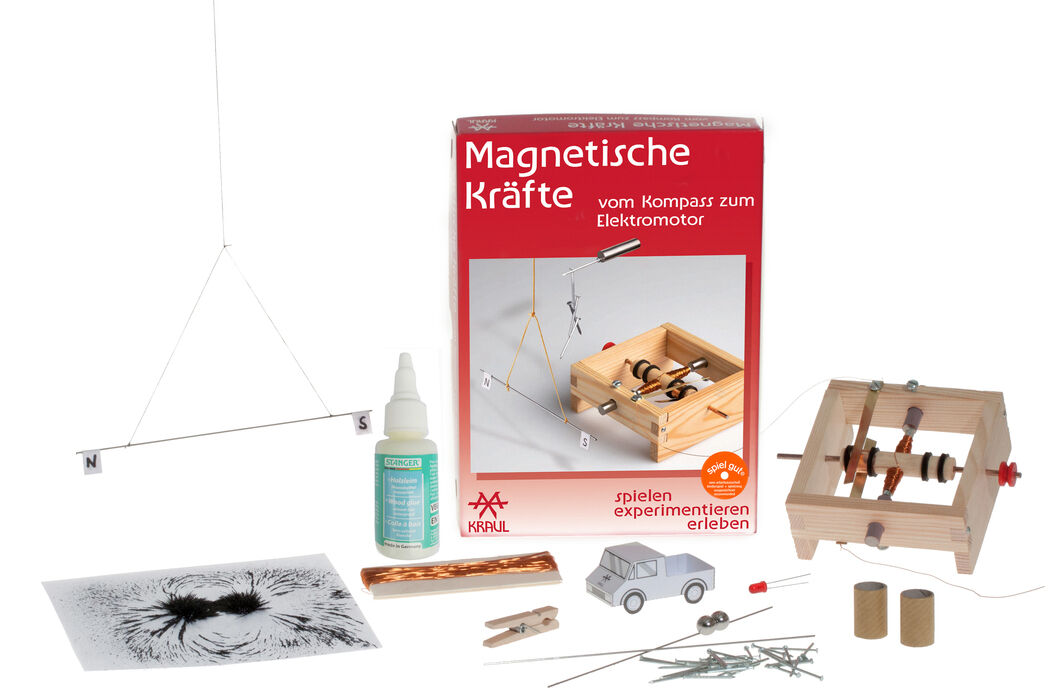 Experimentierkasten »Magnetische Kräfte« zeigt eine Box mit verschiedenen Materialien und Gegenständen wie Magnete, Drähte, eine Holzplattform, Anleitungen und Flüssigkeiten, die für verschiedene wissenschaftliche Experimente verwendet werden können.