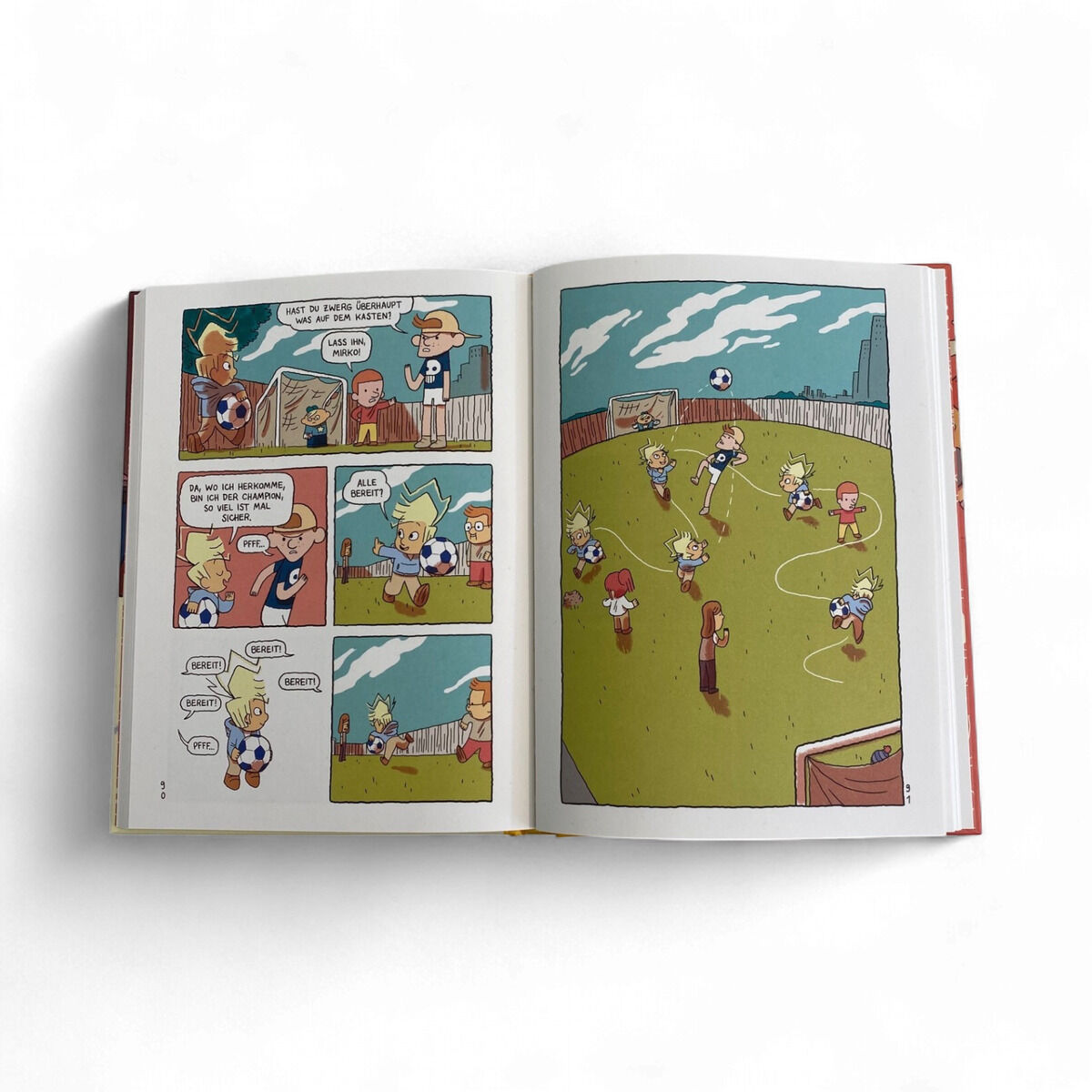 Aufgeschlagenes Comicbuch "Q-R-T. Der neue Nachbar" aus der ZEIT-Edition »Comics für Lesestars«: Links humorvolle Sprechblasen-Szene mit mehreren Kinder-Charakteren, rechts bunte Illustration eines Fußballspiels auf einer Wiese mit Tor, Holzlatten-Zaun und Kindern in Bewegung, weißer Hintergrund.