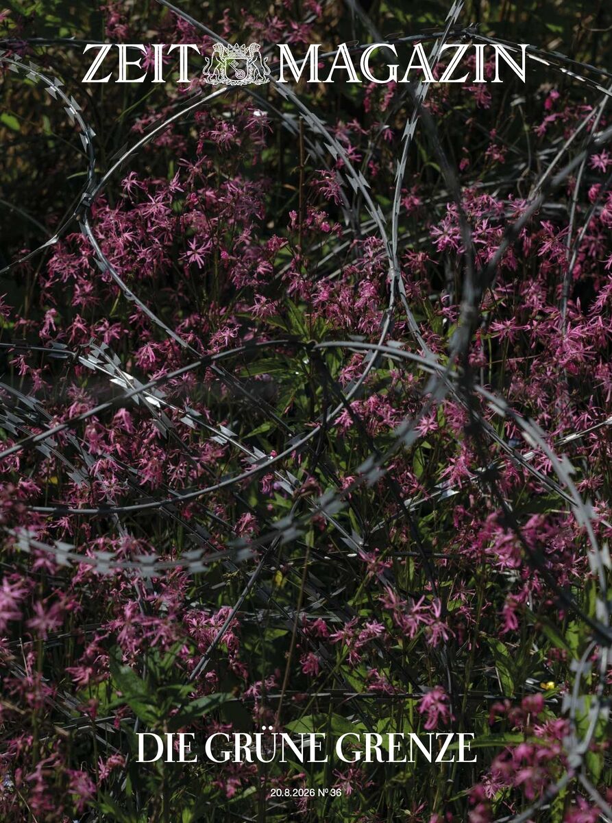 Das Magazincover zeigt ein dichtes Feld violetter Blüten, durchzogen von silbernem Stacheldraht. Der Titel 'ZEIT MAGAZIN' steht oben, der Schriftzug 'DIE GRÜNE GRENZE' unten. Thema ist die Verbindung von Natur und Grenze, das Erscheinungsbild wirkt teils idyllisch, teils bedrohlich.