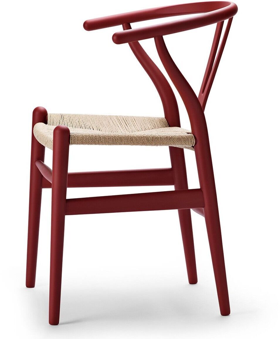 Rot lackierter Designstuhl »Stuhl CH24 Soft« von Carl Hansen mit einer natürlichen beigen Sitzfläche aus Flechtwerk vor weißem Hintergrund.