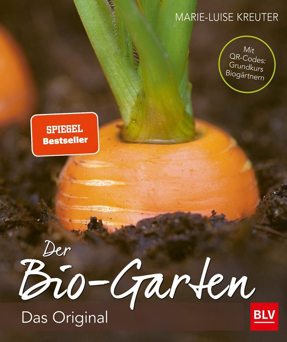 Das Buchcover von 'Der Biogarten' von Marie-Luise Kreuter zeigt eine Nahaufnahme einer teilweise aus der Erde ragenden Karotte. Der Titel ist in einer handschriftlichen Schriftart in weißer Farbe. Das Buch ist ein Spiegel Bestseller.