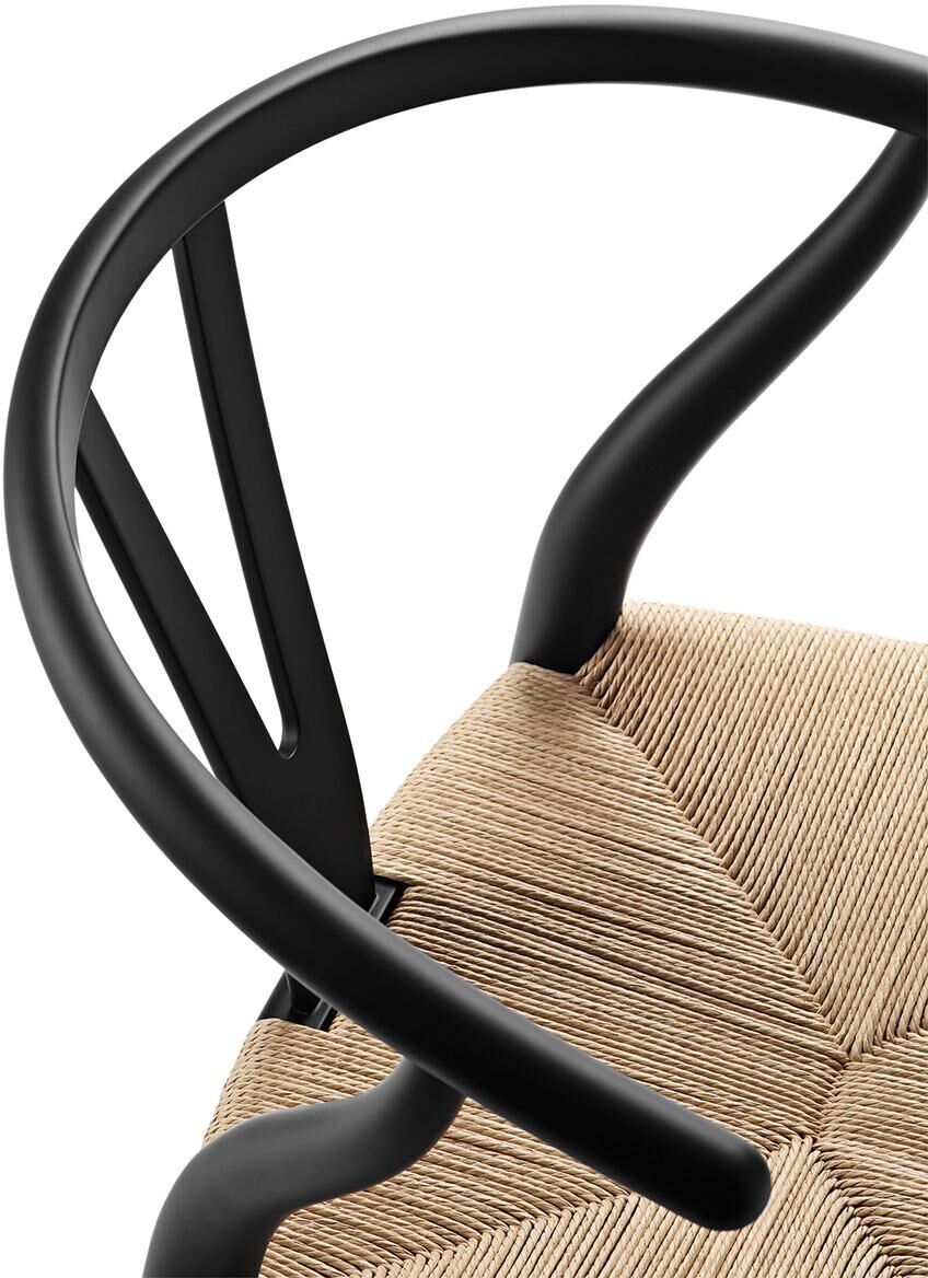 Sonderedition des Stuhls CH24 Soft von Carl Hansen, mit einem minimalistisch geschwungenen schwarzen Rahmen und einer naturfarbenen Sitzfläche aus geflochtenem Material.