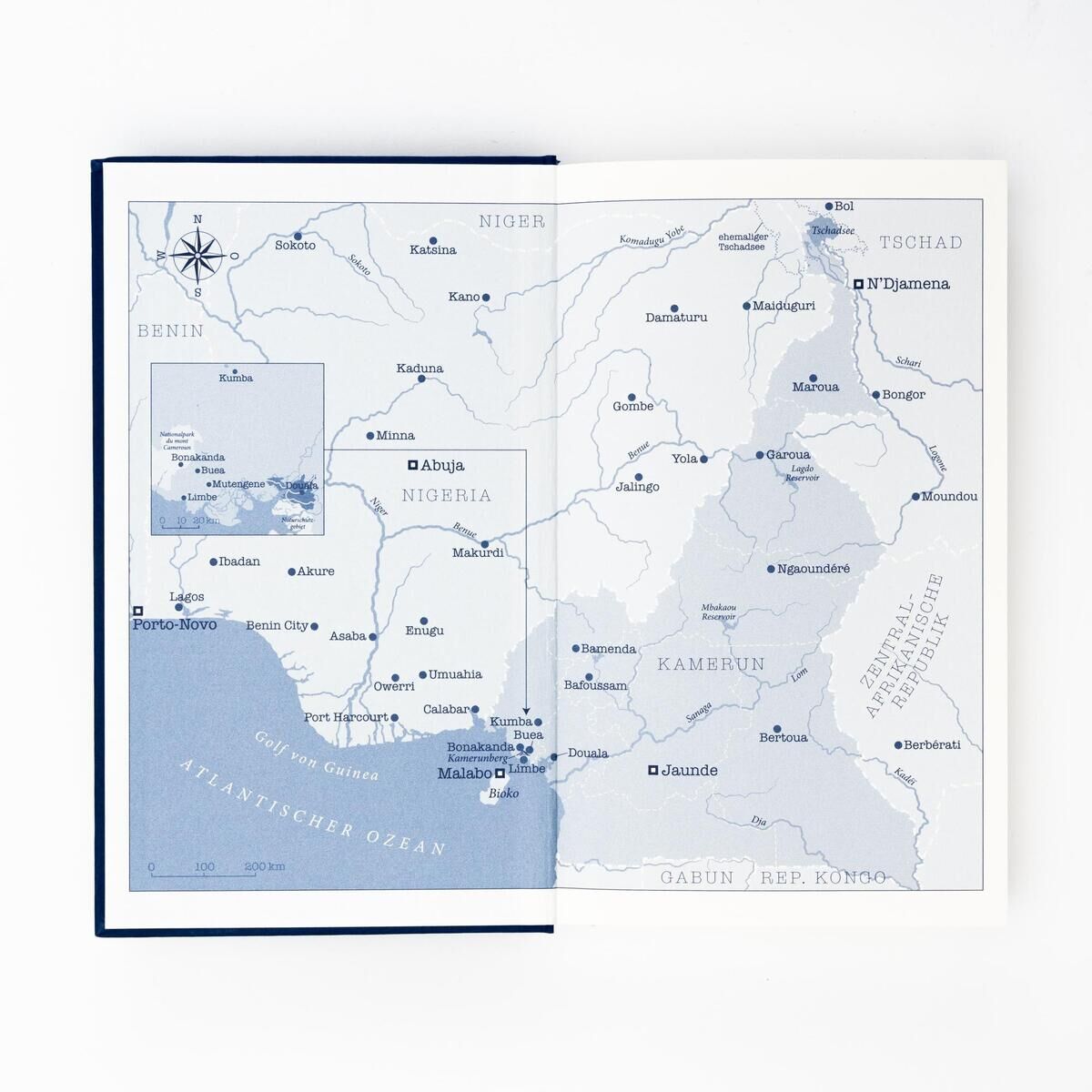 Geöffnete Buchseite mit einer Landkarte von Westafrika, die Nigeria, Kamerun und angrenzende Gebiete zeigt. Die Karte ist in Blau- und Weißtönen gehalten und zeigt Standorte, Städte und geographische Merkmale.