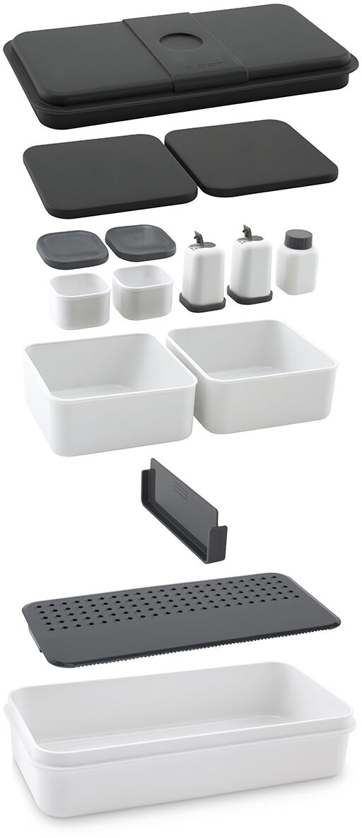 Das Bild zeigt ein modulares Lunch Care System bestehend aus mehreren schwarzen und weißen Plastikbehältern und Deckeln. Gezeigt wird eine Vielzahl von Behältern in verschiedenen Größen, inklusive kleiner Flaschen und Einsätze für eine flexible Essensaufbewahrung. Alle Teile sind stapelbar und bieten vielseitige Verwendungsmöglichkeiten für die Aufbewahrung und den Transport von Mahlzeiten.
