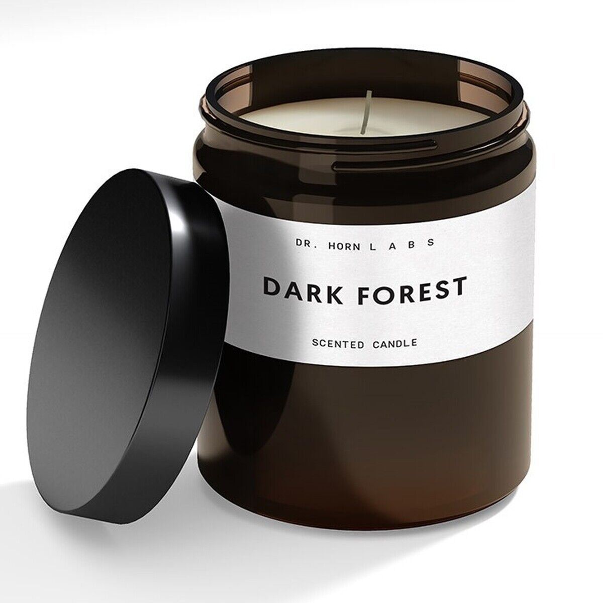 Eine Duftkerze aus Sojawachs in einem braunen Glasbehälter mit schwarzem Deckel. Das Etikett auf der Kerze trägt die Aufschrift 'Dark Forest'.
